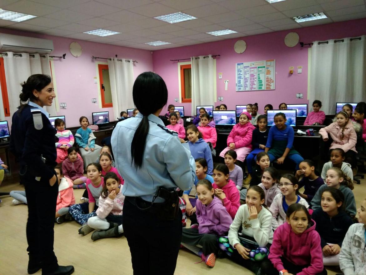 שוטרים ושוטרות מקורס במכללה לשוטרים  מסבירות בהתנדבות על הפח הכתום