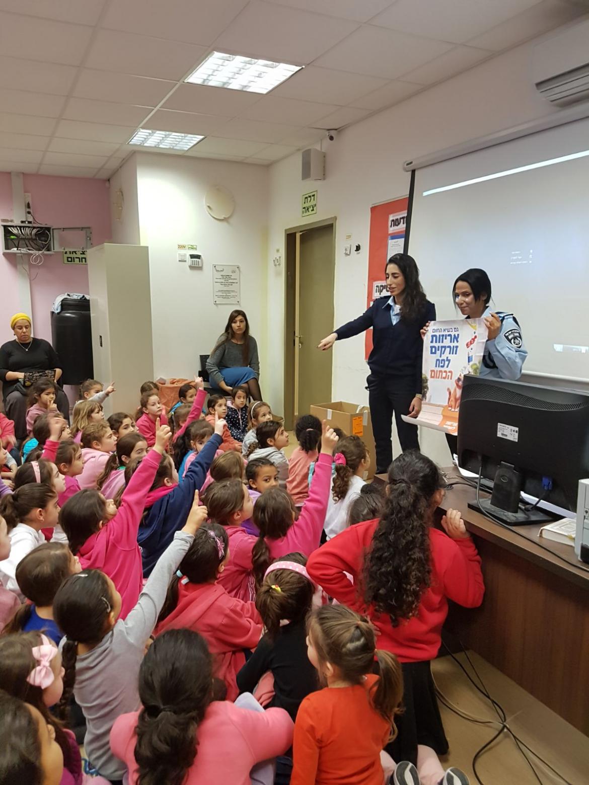 שוטרים ושוטרות מקורס במכללה לשוטרים  מסבירות בהתנדבות על הפח הכתום